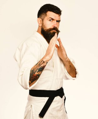 Beyaz arka plan üzerinde beyaz kimono içinde sakallı adam. Siyah kuşak uygulamalar saldırı ya da savunma ile taekwondo master