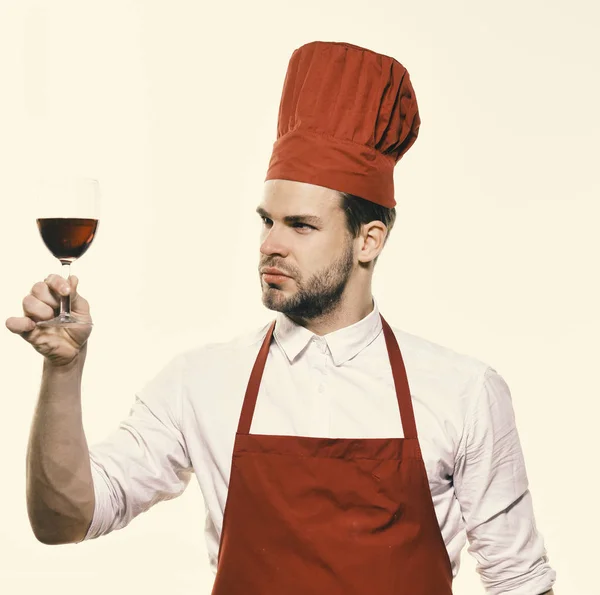 Kock i Bourgogne uniform med glas rött vin. Laga mat med nöjd ansikte ser på vinglas. Italienska dryck koncept. — Stockfoto