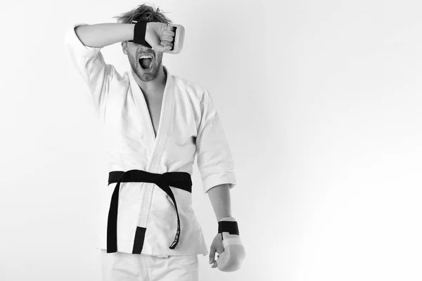 Fighter MMA z silne ciało praktyk sztuk walki. Facet stawia w białe kimono noszenia złote rękawice bokserskie — Zdjęcie stockowe