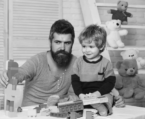 Erkek ve çocuk birlikte oynuyorlar. Baba ve çocuklu oyuncaklar