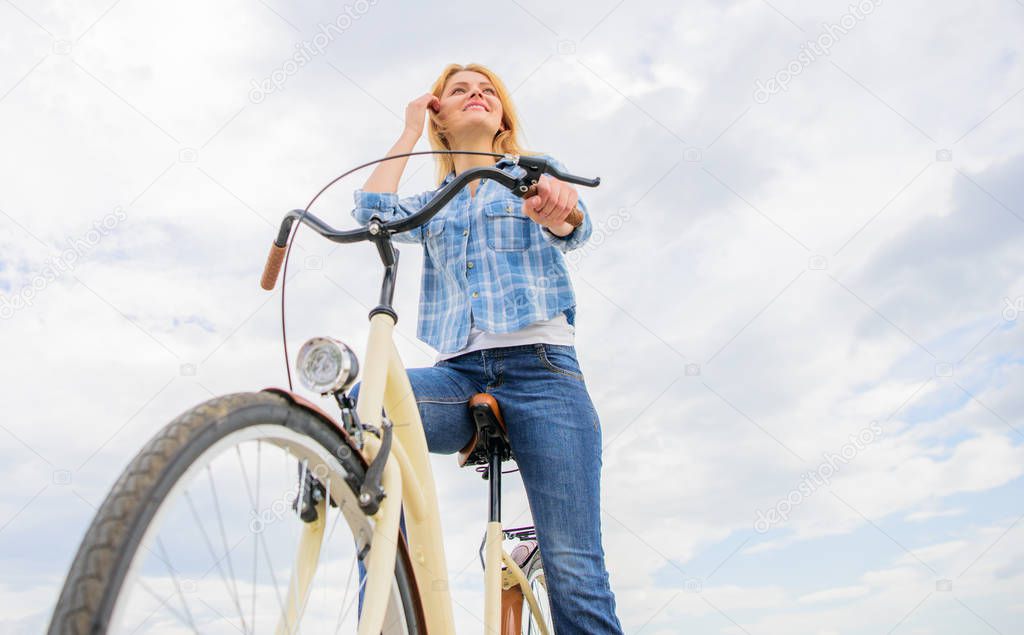 Bike rental shops primarily serve people who do not have access to vehicle typically travellers and particularly tourists. Woman rent bike to explore city copy space. Girl rides bike sky background
