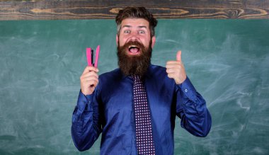 Gülümseyen adam zımba Kırtasiye tutun. Öğretmen adam zımba kara tahta arka plan ile sakallı. Okul sezonu satın Kırtasiye için hazırlayın. Yenilikçi öğretmen resmi kravat zımba tutar. Okul kırtasiye