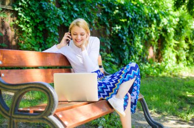 Kız sit tezgah notebook arama telefon ile. Online alışveriş ile zaman kazanmak. Online alışveriş. Park içinde kadın laptop yeşil doğanın ve temiz havanın tadını çıkarın. Kız rüya gibi online alışveriş yararlanır