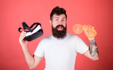 Alternatif gerçeklik. Sanal gerçeklik kulaklık ve kırmızı zemin üzerine çok güneş gözlüğü sakallı adam hippi. Gerçeklik ve Vr. adam seçmek ne gerçek veya sanal karar arasında seçim