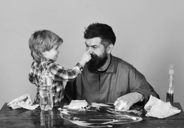 Temizlik faaliyetleri kavramı. Baba ve çocuk pembe bir arka plan üzerinde masada.