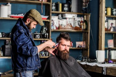 Kuaför saç kesme makinesi ile saç modeli sakallı adam berber arka plan için çalışır. Clipper kırpma kıllı istemci Tapınağı berber. Hipster yaşam tarzı kavramı. Hipster istemci Başlarken saç kesimi