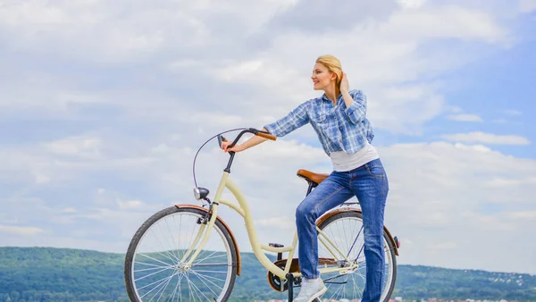 Avantages du vélo pour la santé. Femme monte vélo fond ciel. Augmentez la force musculaire et la flexibilité en faisant du vélo. Avantages du vélo tous les jours. Fille en vélo de croisière. Raisons de faire du vélo — Photo