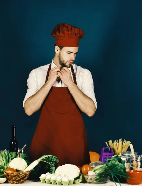 Geschirr und Kochkonzept. Köchin arbeitet in Küche am Tisch mit Gemüse und Werkzeug — Stockfoto