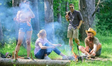 Büyük piknik için toplama. Çayır takılmak ve hazırlamak için toplantı arkadaşlar sosis aperatifler doğa arka plan kavrulmuş. Yaz piknik katılın. Sosis sopa üzerinde kavurma sırasında eğlenmek Şirket