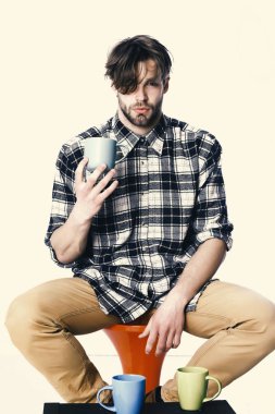 Beyaz arka plan üzerinde izole mavi Kupası holding ciddi bir yüz. yakışıklı adam beyaz arka plan üzerinde izole bardak