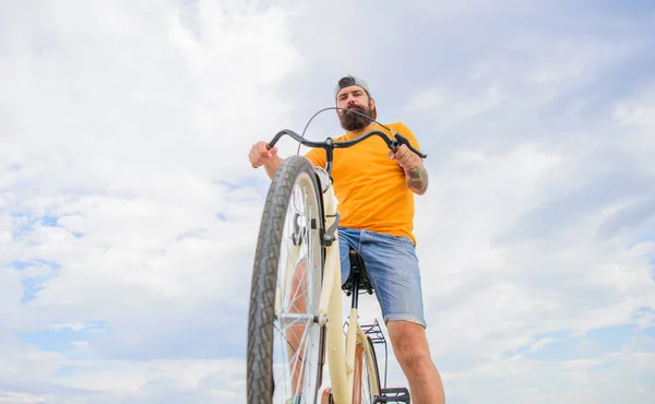 Homem barbudo hipster passeios bicicleta fundo vista céu fundo. Cultura moderna de andar de bicicleta. Otimize o desempenho do ciclismo. Superar obstáculos na bicicleta. Hipster pronto para executar truque — Fotografia de Stock