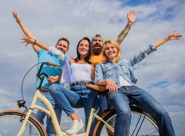 Bicycle as part of life. Cycling modernity and national culture. Group friends hang out with bicycle. Share bike live eco friendly. Company stylish young people spend leisure outdoors sky background