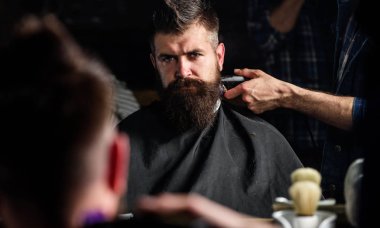 Saç kesme makinesi kırpma ense istemci ile yansımanın berberler el. Hipster sakallı istemci saç ayna önünde alıyorum. Berber kavramı. Defocused saç kesme makinesi kırpma ense ile berber