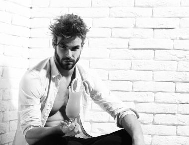 kaslı çıplak gövde cam alkollü Orange kokteyl beyaz tuğla duvar arka planda tutan atletik vücut üzerinde. yakışıklı sakallı maço seksi adam