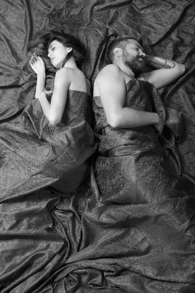 Homem com barba e rosto sonolento dorme com senhora na cama, vista superior. Homem e mulher deitam-se no quarto — Fotografia de Stock