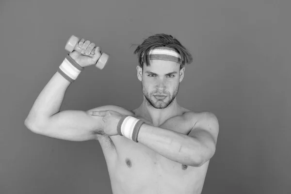 Un type avec des poils à la tête et des bracelets. Homme avec corps nu et biceps forts détient haltère — Photo