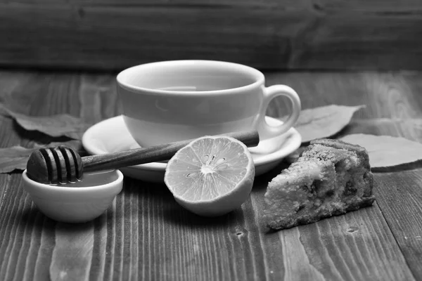 Concepto de bebida caliente de otoño. Taza de té con miel, cuchara de madera y pastel, composición otoñal — Foto de Stock