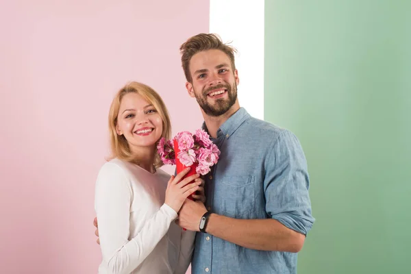 Man gratulerar kvinna födelsedag årsdagen semester, pastellfärgade bakgrunden. Gåva-konceptet. Par datum bukett blommor gåva. Par i kärlek firar semester. Man ger bukett blommor till flickvän — Stockfoto