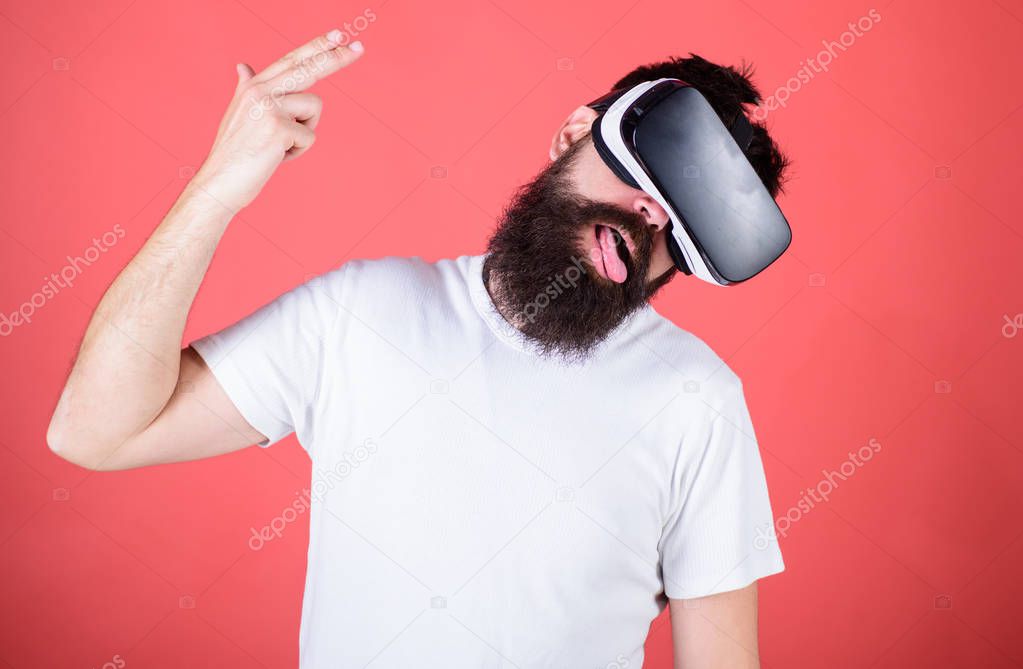 First person shooter shows how addictive VR could be. Suicide shot game. Man hand gesture as gun play shooter game in VR glasses. Man bearded hipster with virtual reality headset on red background