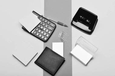 Hesap makinesi, delik açma, iş kart sahibi, not kağıdı, kalem ve klipleri. Renkli arka plan üzerinde üstten görünüm izole office araçları