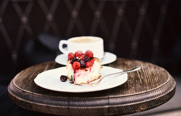 Cheesecake with berries and coffee on wooden table, close up. Confectionery concept. Piece of cake with blackberries and raspberries — Stock Photo, Image
