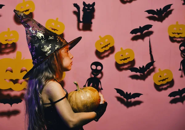Halloween decoraties concept. Kleine heks dragen zwarte hoed. Kid in spooky heksen kostuum — Stockfoto