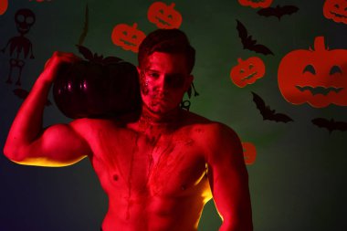 Korkunç yüzlü ve koyu yeşil gövdeli bir adam.