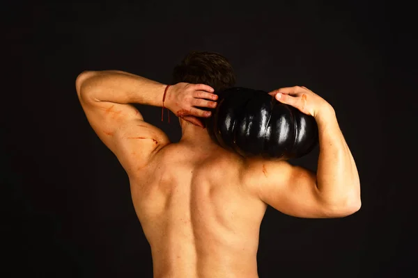 Mann mit nacktem Oberkörper demonstriert Muskeln auf schwarzem Hintergrund. — Stockfoto