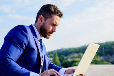 Sosyal medya pazarlama uzmanı mavi gökyüzü arka çalışır. İşadamı sörf internet veya yanıt e-postalar ile dizüstü bilgisayar açık havada oturup süre. Markanızın online itibar. Online itibar ipuçları artırın
