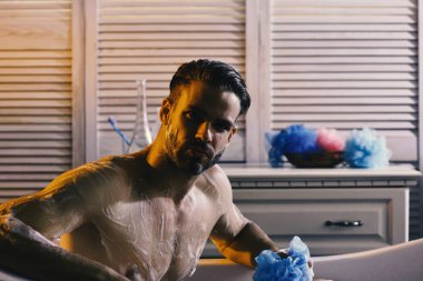 Küvette, seçici odak çıplak oturan maço. Köpük, seçici odak kaplı banyo adam
