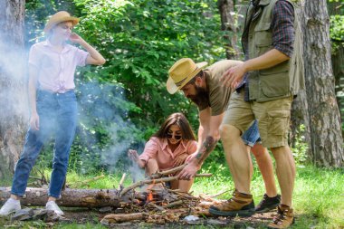 Şenlik ateşi tutmak için takım olarak çalışma arkadaşlarım. Orman kamp şirket gençlik şenlik ateşi piknik için hazır olun. Ateş etmek için biraz tahta ekleyin. Şirket arkadaşlarınız veya aileniz şenlik ateşi Orman Doğa arka planda yapma