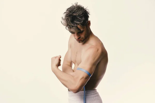 Sport und Gewichtsverlust Konzept. Mann mit Handtuch und flexiblem Lineal isoliert auf weißem Hintergrund — Stockfoto