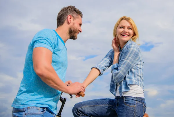 Asual acquaintance concept. Man with beard and shy blonde girl on first date. Couple just meet to hang out together. Woman feels shy in company with attractive macho. Rolling romance or bike date — Stock Photo, Image