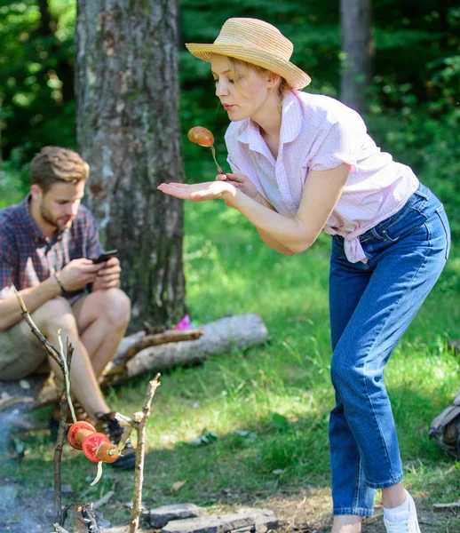 Girl in straw hat trying roasted food nature background. Delicious picnic food. Tips every camper should know about campfire cooking. Easy tips improve your campfire cooking. Foods to cook on stick