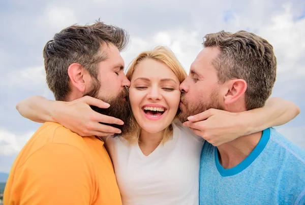 Todo lo que debe saber evitar la zona de amigos empezar a salir. Los hombres besan a la misma chica en las mejillas. Le gusta la atención masculina. Chica abrazos con dos chicos. Relaciones amistosas. Guía definitiva evitando la zona de amigos — Foto de Stock