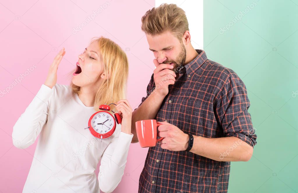 Lack of sleep. Couple sleep not enough time. Family drink morning coffee yawning faces. Hate morning awakening. Harmful habit to oversleep. Couple oversleep awakening hold alarm clock