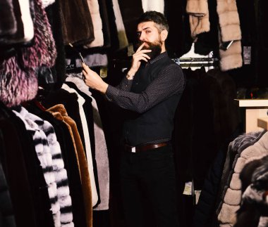 Maço ile arka plan üzerinde kürklü ceket. Kürk manto düşünceli yüzü olan adam görünüyor.