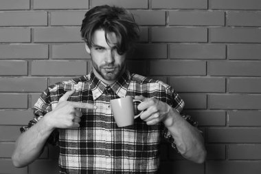 ciddi bir yüz tutan sarı Kupası dokulu tuğla duvar arka plan, kopya alanı, yakışıklı adam tuğla duvar arka plan üzerinde Kupası