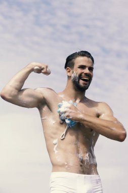 Adam gülüyor ve kasları Berrak gökyüzü arka plan üzerinde gösterilen kıl. Adam gülüyor ve kas gösterilen kıl ile