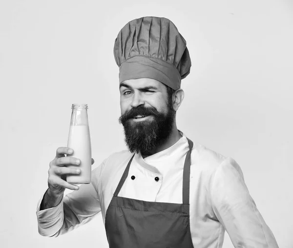 Mannen med skägg innehar flaska mjölk på vit bakgrund. Kock med milkshake eller yoghurt. Hemlagad matkoncept — Stockfoto