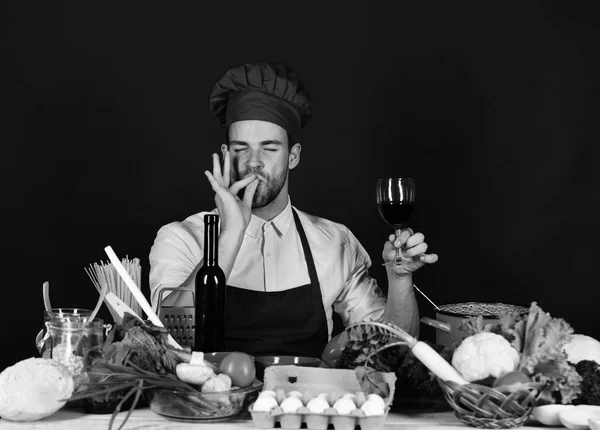 Кухар працює кухні поблизу овочі та інструменти. Італійський напій і сомельє концепції. Людина в капелюсі і фартух — стокове фото