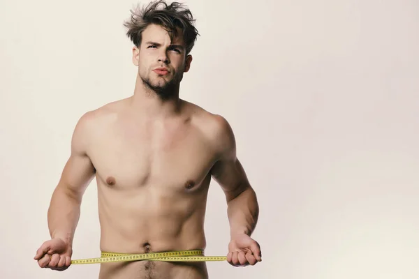 Concepto de pérdida de peso y deportes. Hombre con cinta amarilla larga medida alrededor del torso desnudo — Foto de Stock