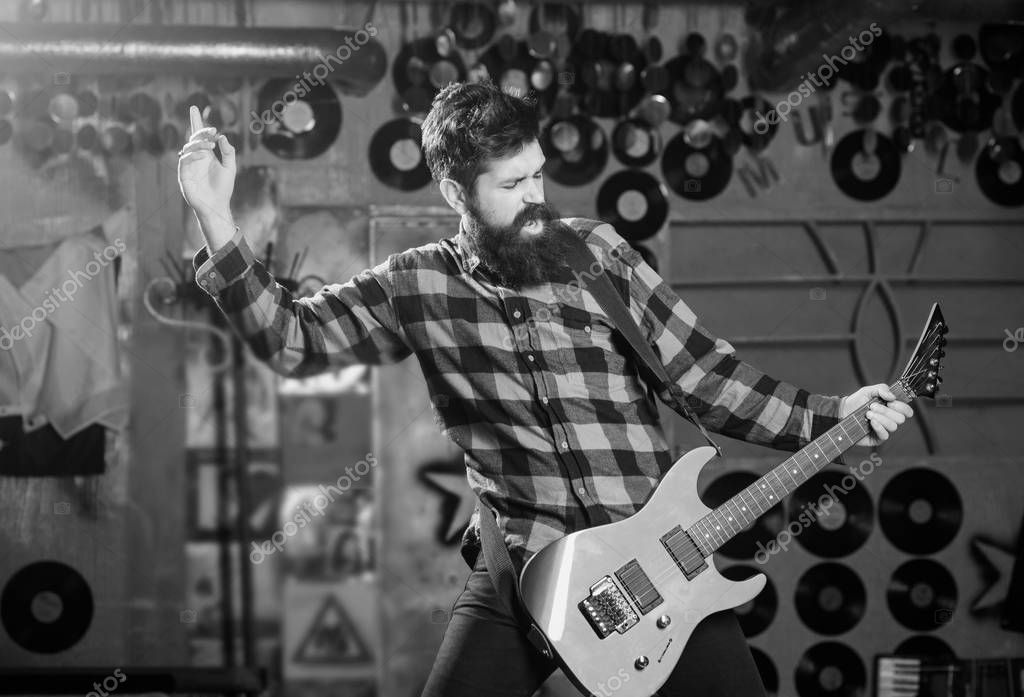 Músico con barba toca la guitarra eléctrica. Hombre con cara de grito