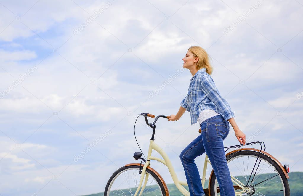 How to learn to ride bike as an adult. Girl ride bicycle. Healthiest most environmentally friendly and most satisfying forms of self transportation. Woman rides bicycle sky background. Active leisure