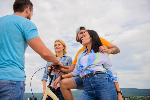 Company stylish young people spend leisure outdoors sky background. Couple meet cheerful friends with bicycle during walk. Cycling modernity and national culture. Group friends hang out with bicycle