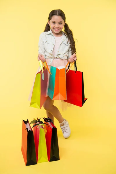 Package and girl. girl with colorful package. shopping package in hand of girl. girl with package bag. little shopaholic. — Stock Photo, Image