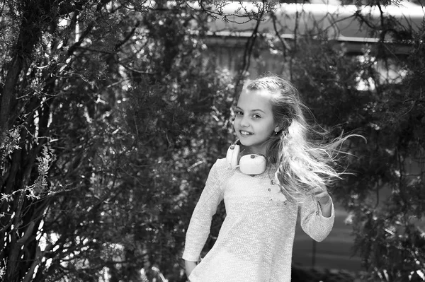 Som musical em mp3. Menina feliz dança à música no parque de verão. Criança pequena gosta de música em fones de ouvido ao ar livre. Kid dançarina sorrir com cabelos longos voando. Verão diversão e alegria — Fotografia de Stock