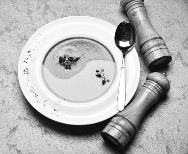 Yeşil ve sarı renkli yin yang işaretiyle pepperbox, saltcellar ve kaşık olarak püre. Geleneksel mutfağı kavramı. Ispanak ve kabak kremalı çorba