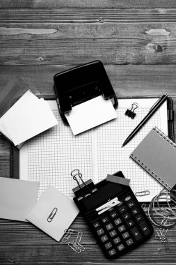 Ahşap arka plan üzerine açık kopya alanı ile defter. Tutucu, klipler ve ihtiyaçları ile sopa renkli kartvizit