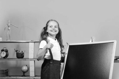 Eğitim ve okul kavramı dön. Kız boş yazı tahtası üzerinde kopya alanı Yazar.